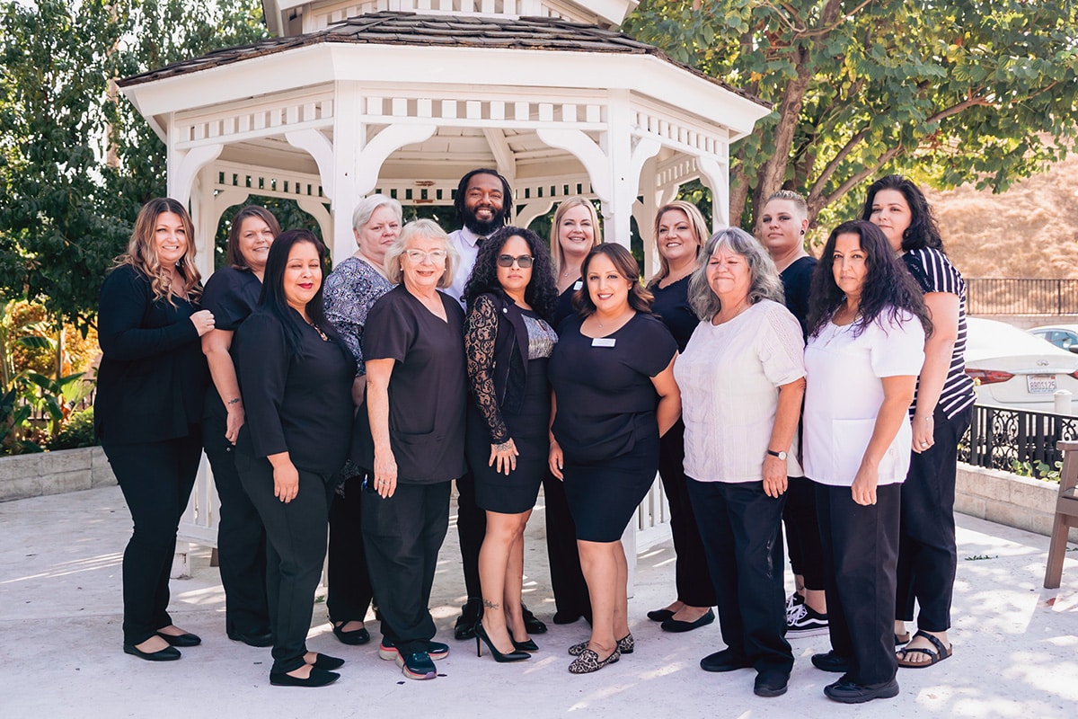 Del Rosa staff members outside standing in front of white gazebo and smiling.
