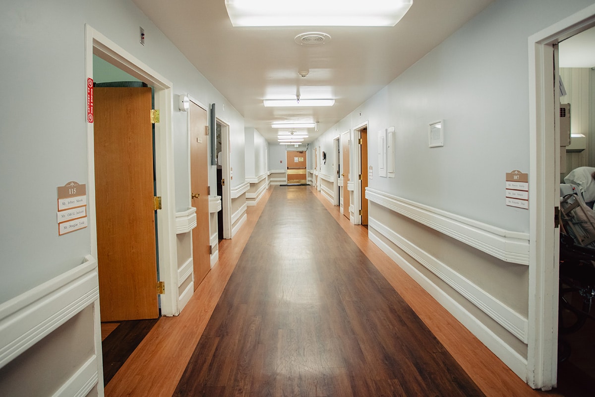 Del Rosa super wide hallway with hardwood floors and chair railing on walls.