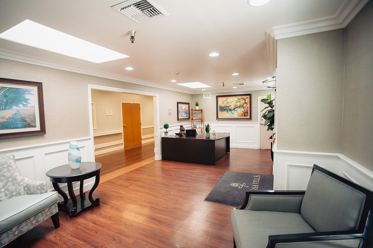 Del Rosa entrance lobby with reception desk, paintings on the wall and hardwood floors.